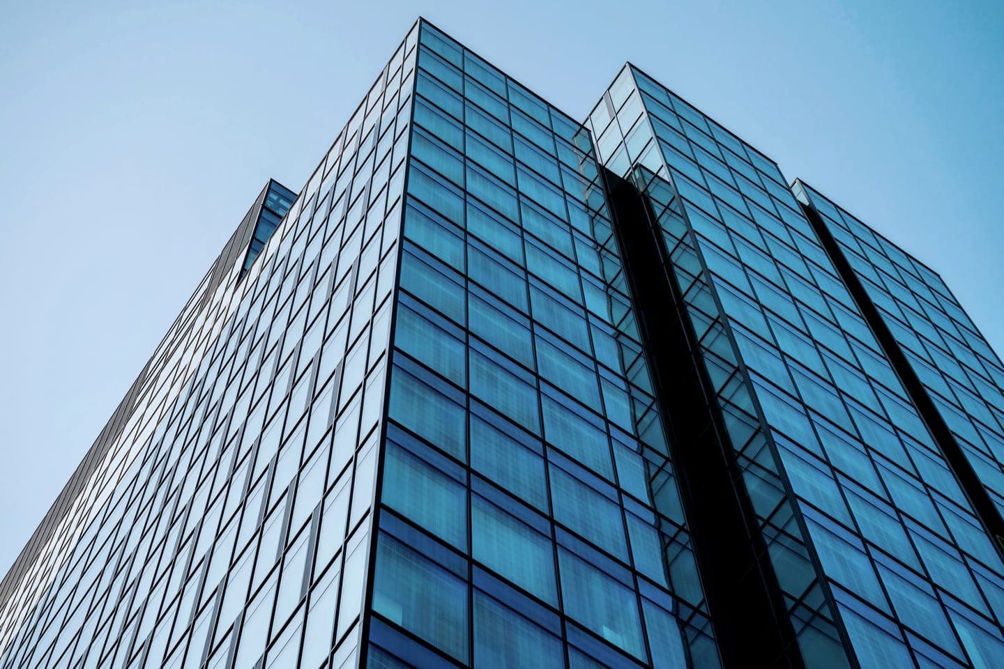 Glass office tower against a blue sky