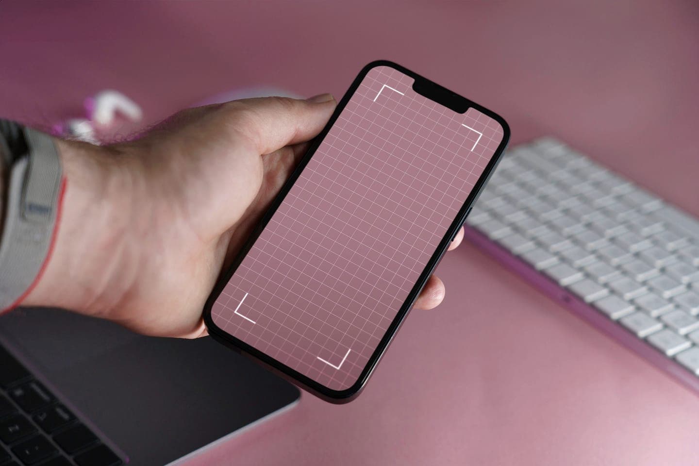 A hand holding a smartphone with a camera scanning frame on screen
